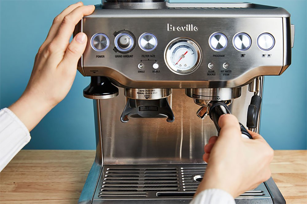 A fresh espresso shot and coffee grounds for the best espresso machine.