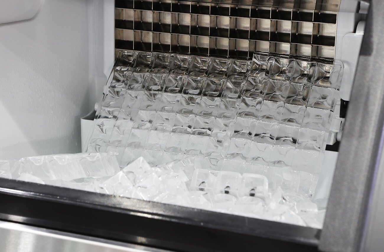 Mineral scale buildup on a commercial ice machine evaporator plate causing irregular ice.