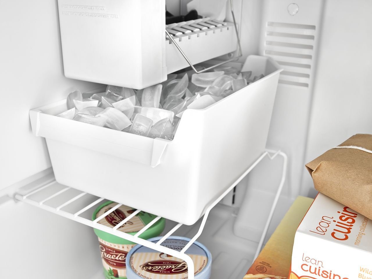 A full freezer bin with a shut-off arm indicating the ice is ready.