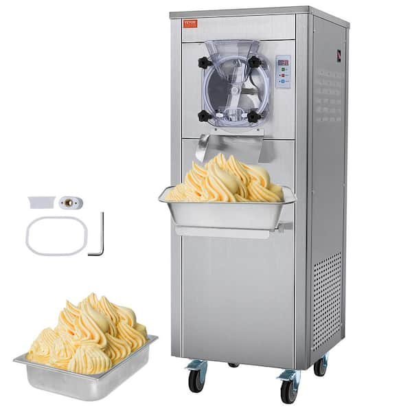 A technician checks the technical connections of a professional batch freezer in a kitchen.