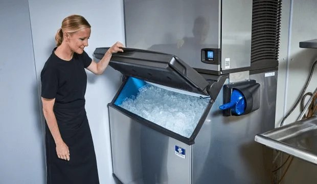 Modern ice machines for home and commercial use sitting on a kitchen counter.