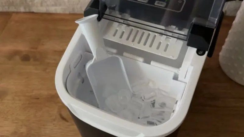 A countertop ice machine producing fresh ice in a bright, modern kitchen.