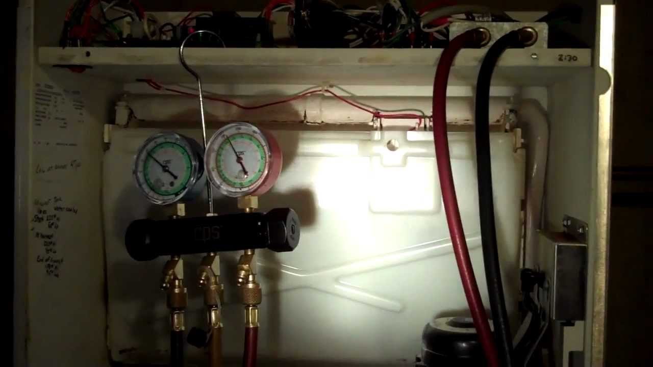 A technician checking refrigerant weight for a commercial ice machine service task.
