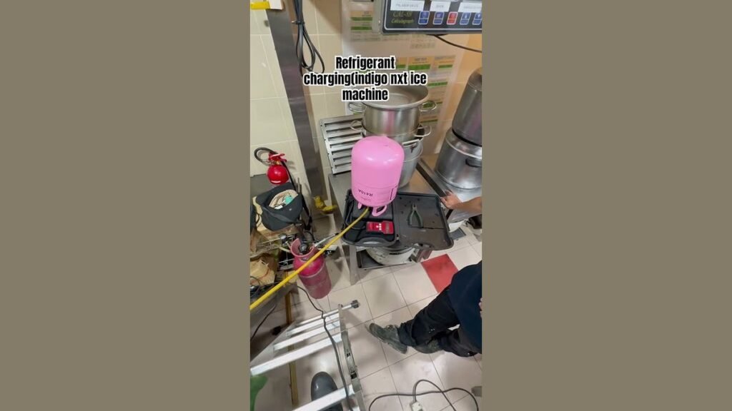 A technician using a digital scale to accurately charge a commercial ice machine.