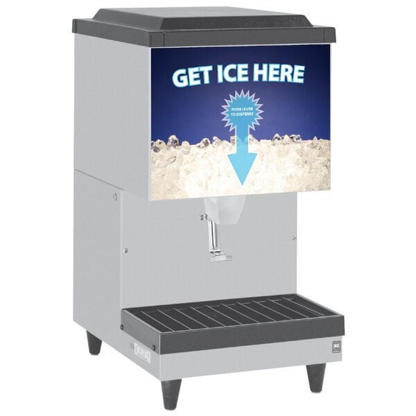 A countertop ice maker sits next to an owner's manual and a measuring cup.