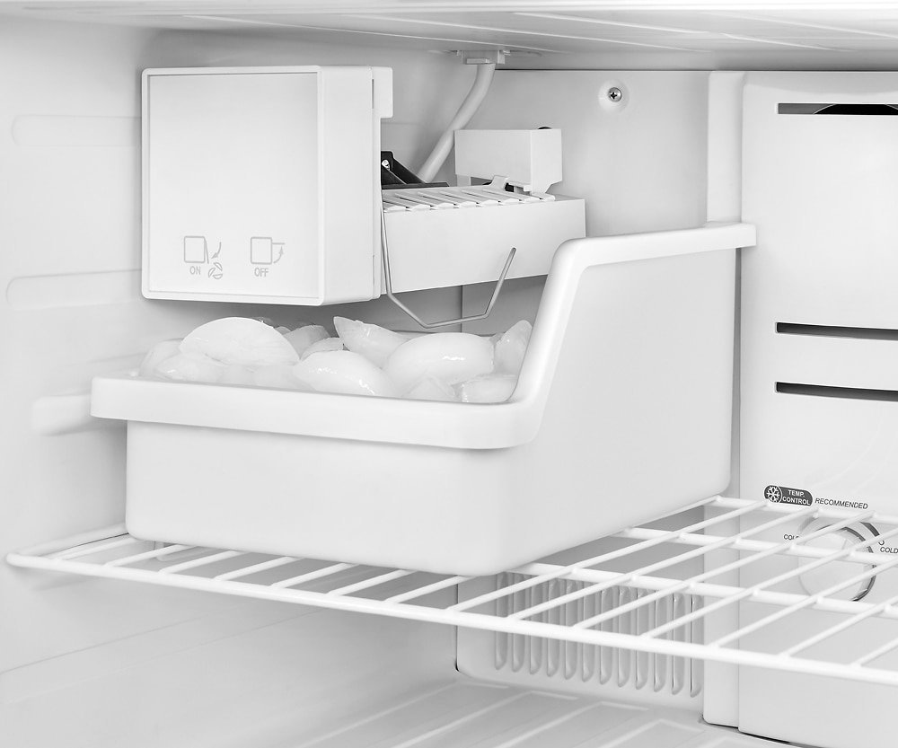 Close-up view of the mechanical parts and water line inside a freezer.