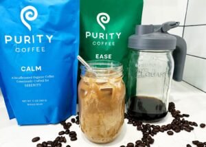 A refreshing glass of cold brew coffee served with coarse coffee beans.
