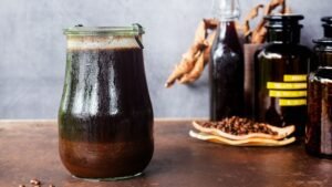 A refreshing glass of cold brew coffee sits on a marble countertop.