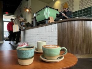 A steaming mug of artisanal coffee sits on a table in a cozy cafe.