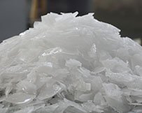 A laboratory researcher adds flake ice to a beaker for cooling samples.