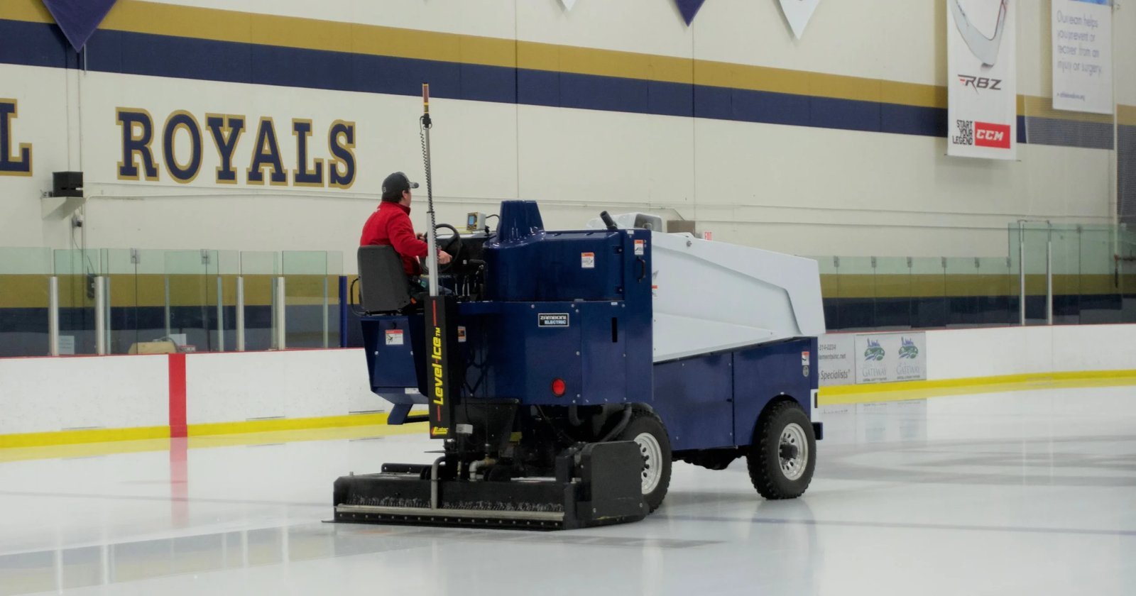 An ice resurfacer machine smoothing the surface of a professional hockey rink.