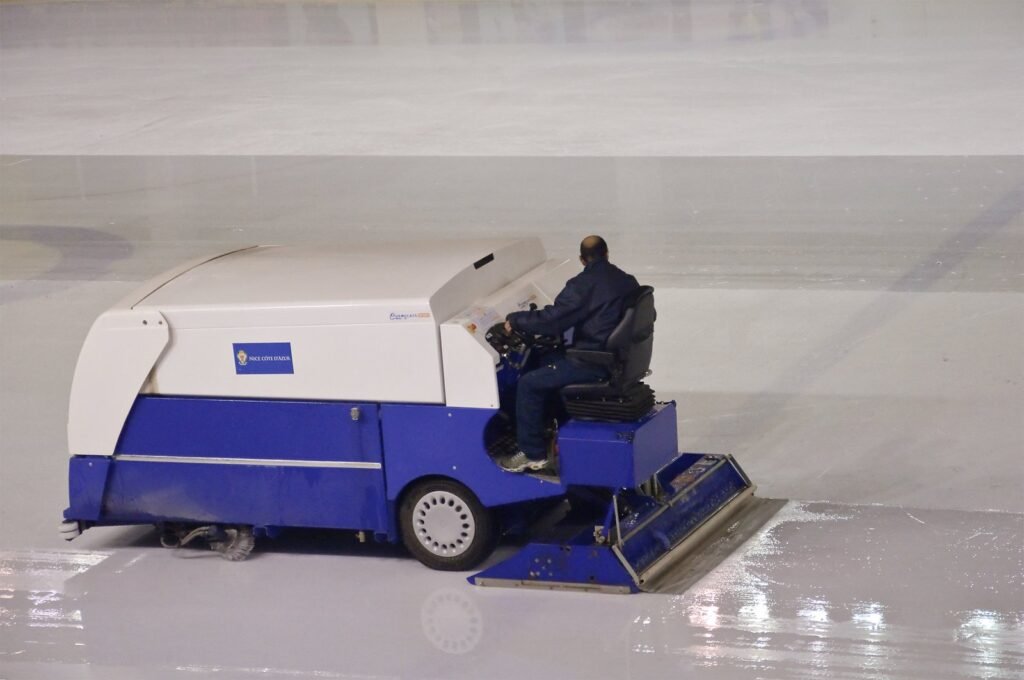 An ice resurfacer sits on the smooth ice of a professional hockey rink.