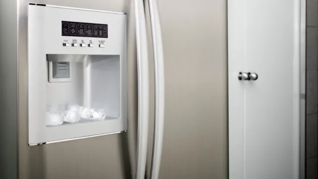 Clear plastic bin filled with solid ice cubes from a fast ice maker.