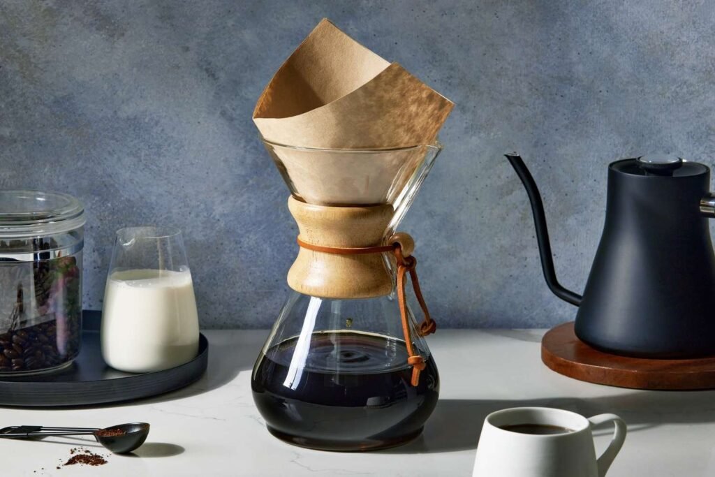 Curated Christmas coffee gifts displayed on wooden table with steaming mug