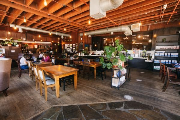 A fresh pour over coffee brewing in a bright Seattle coffee shop.
