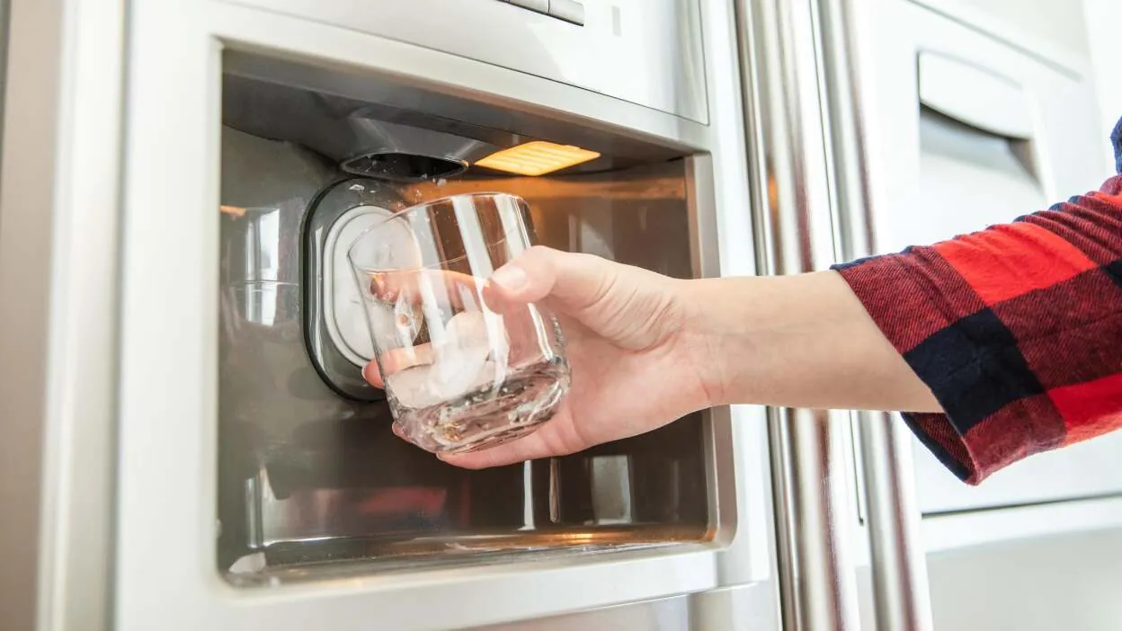 Frozen water supply tube with frost inside open freezer compartment