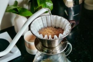 A minimalist pour over coffee setup bathed in soft morning light on a wooden counter.
