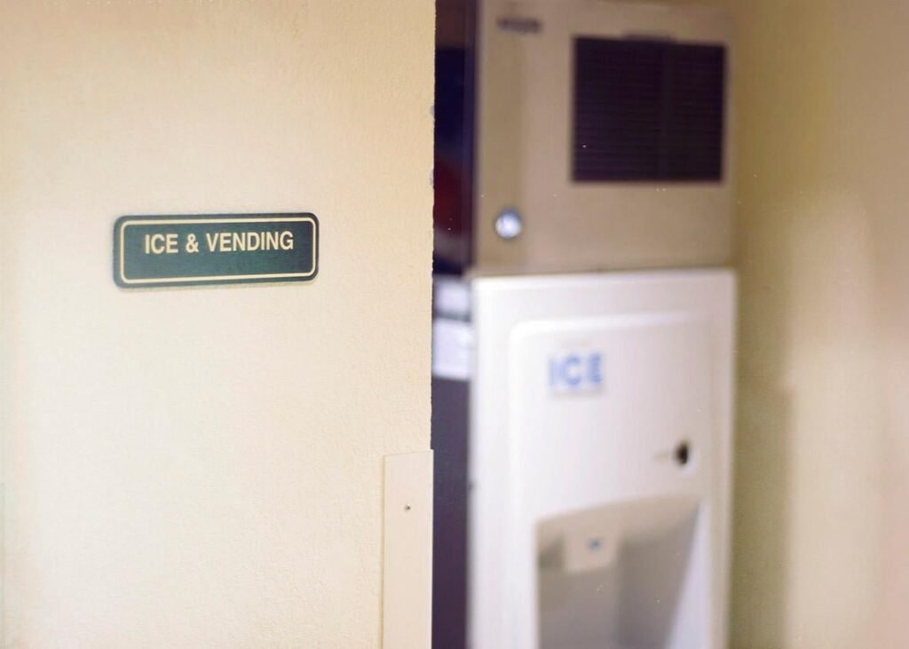 A modern ice machine station located in a quiet hotel hallway corridor.