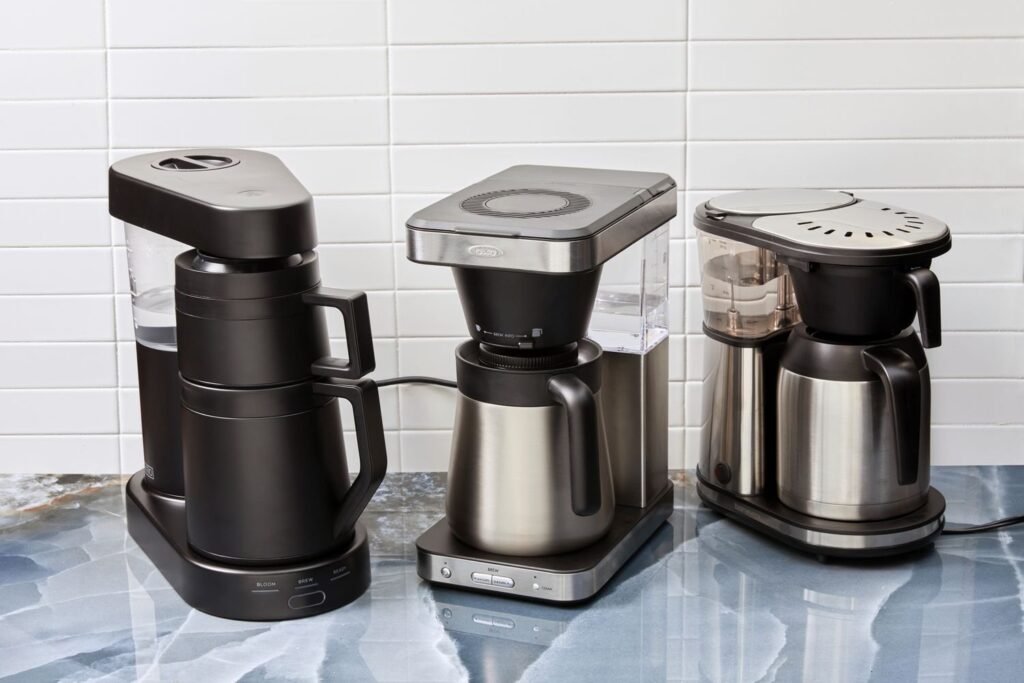 A professional coffee brewer preparing a large batch of fresh coffee in a cafe.