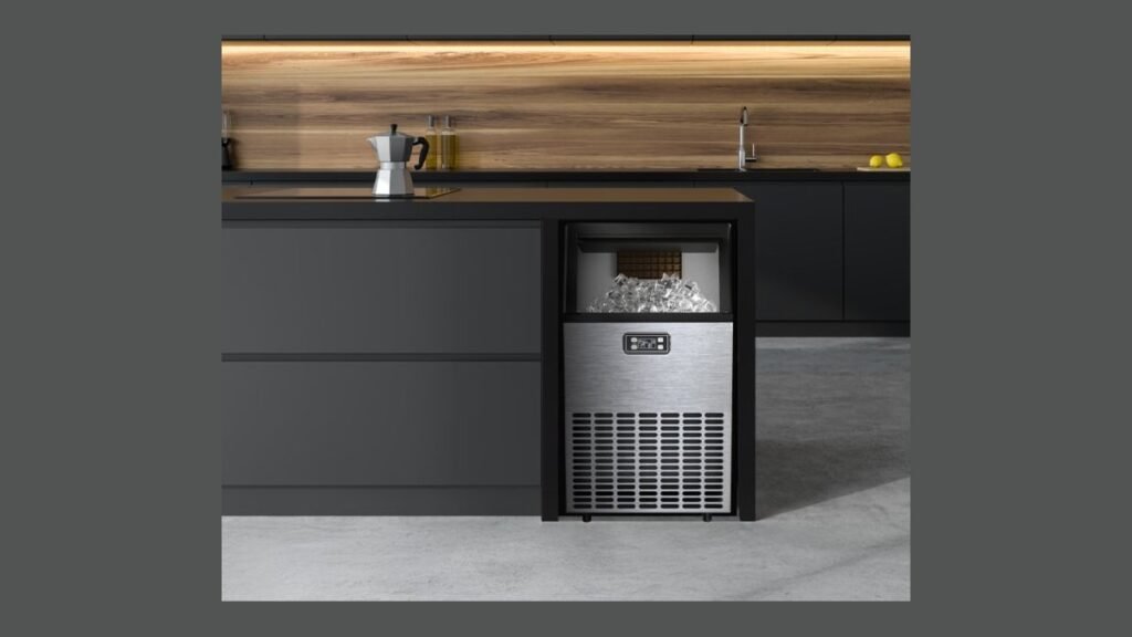Stainless steel countertop ice maker on white kitchen counter at night