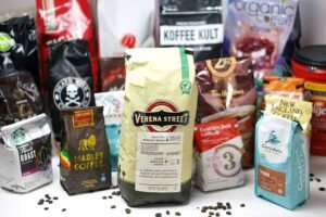 A steaming cup of delicious coffee next to beans representing the best tasting coffee brands.