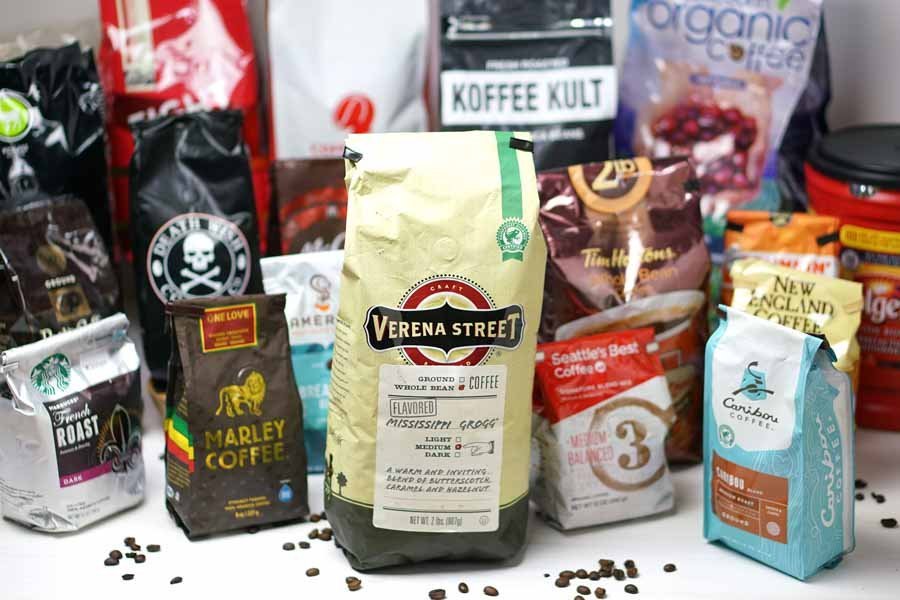 A steaming cup of delicious coffee next to beans representing the best tasting coffee brands.
